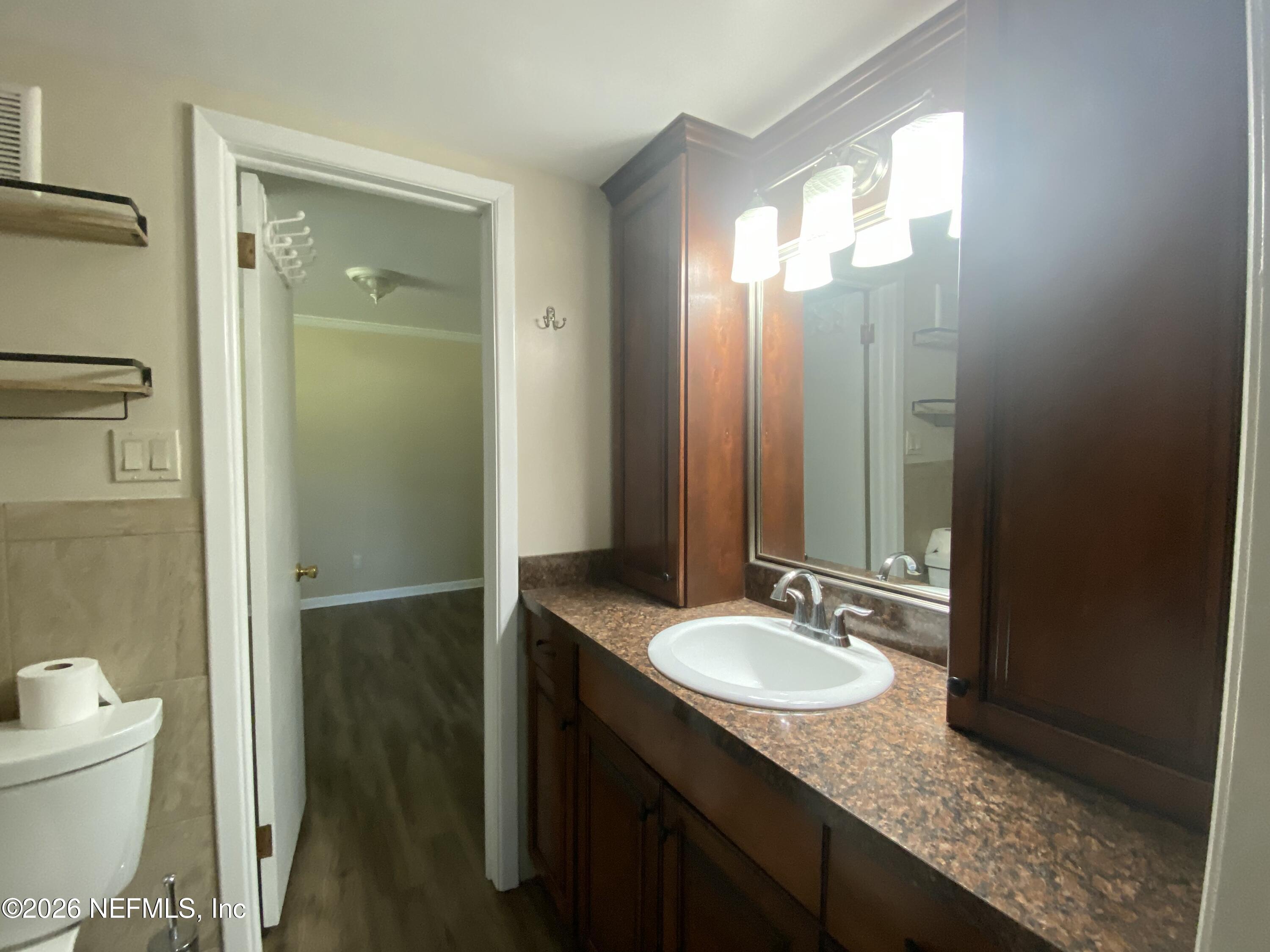 104 St Elmo Road Green Cove Springs, FL 32043 - Photo 13 of 24 a bathroom with a granite countertop sink and a mirror