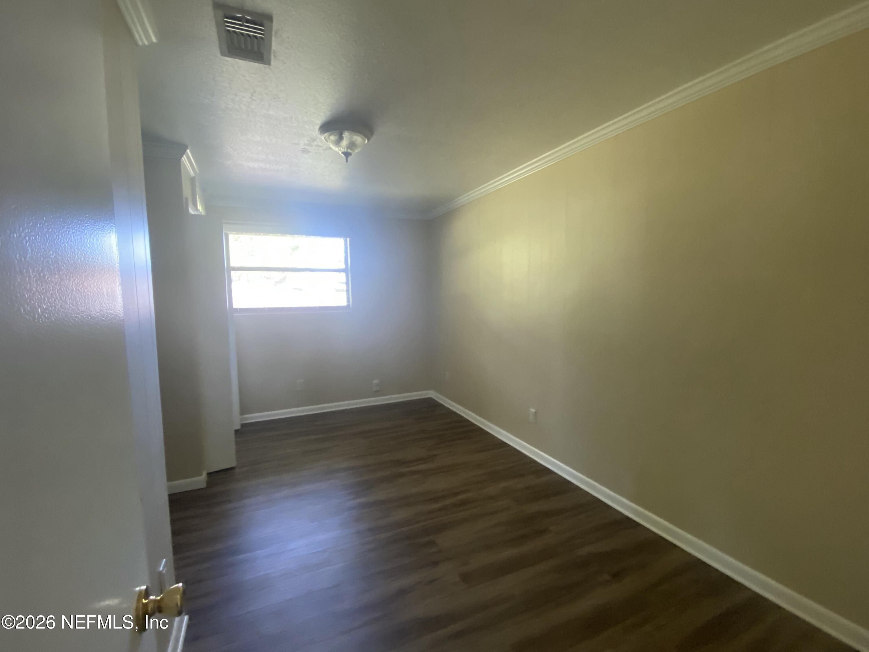 104 St Elmo Road Green Cove Springs, FL 32043 - Photo 16 of 24 an empty room with wooden floor and windows