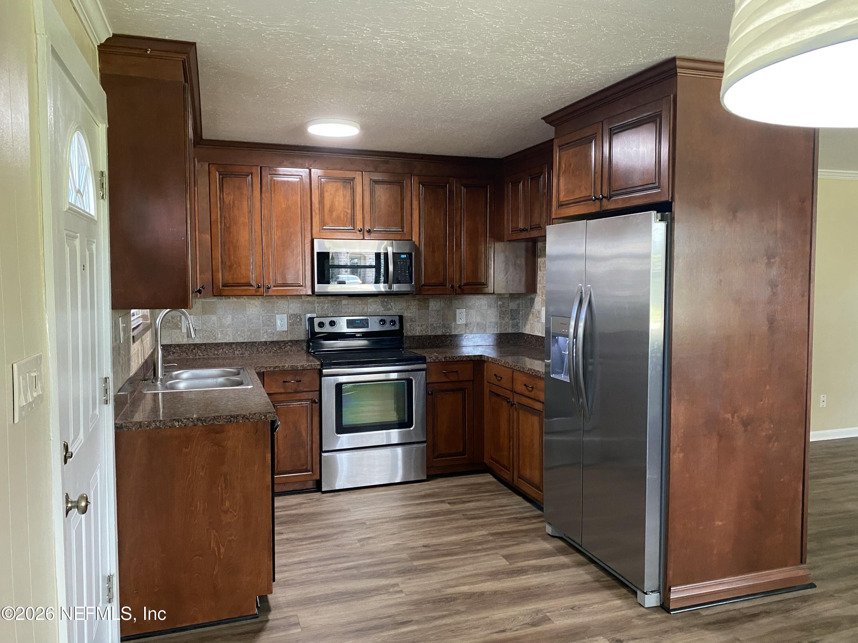 104 St Elmo Road Green Cove Springs, FL 32043 - Photo 5 of 24 a kitchen with granite countertop a refrigerator stove and oven