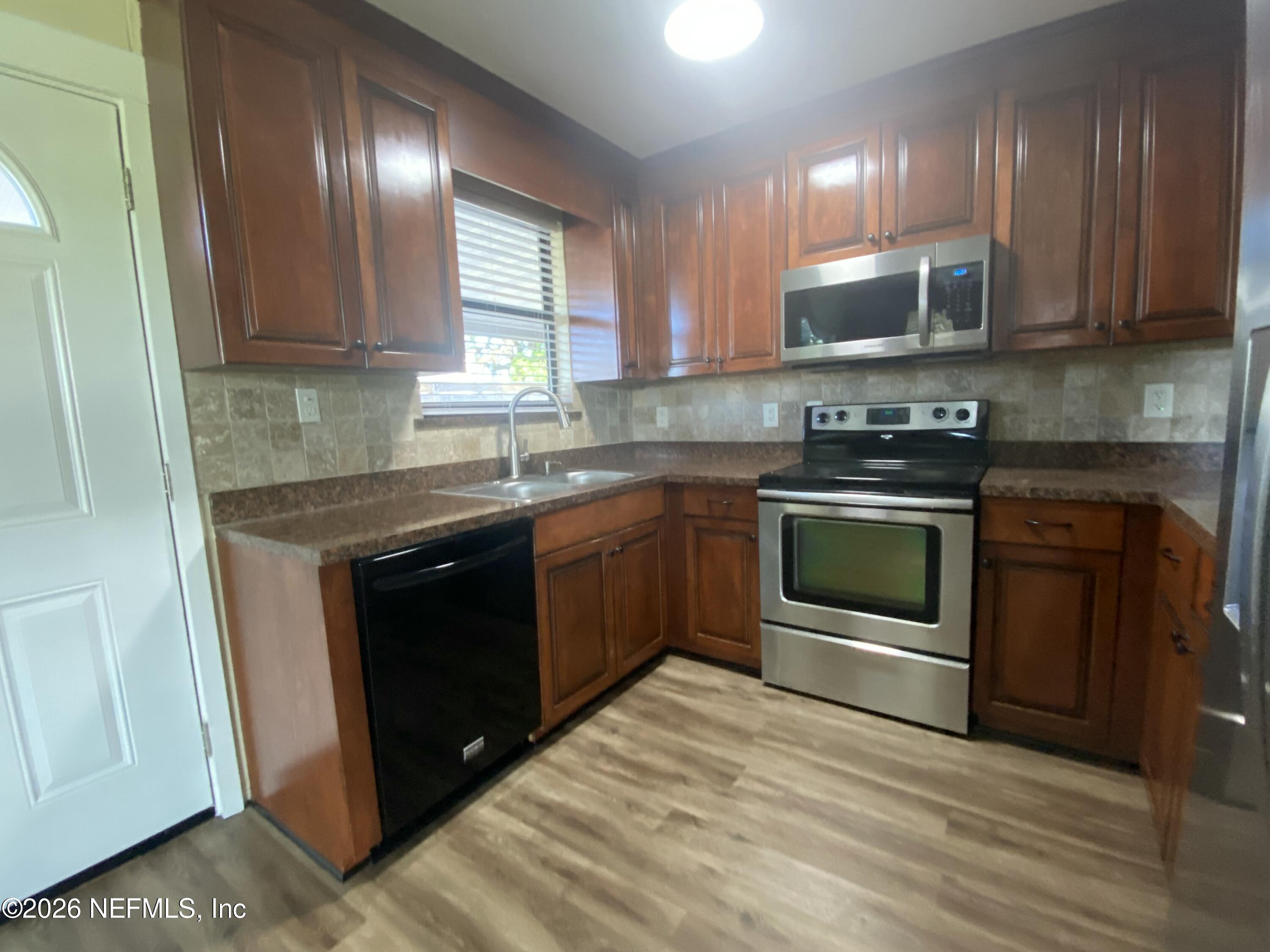 104 St Elmo Road Green Cove Springs, FL 32043 - Photo 6 of 24 a kitchen with stainless steel appliances granite countertop a stove a sink and a microwave