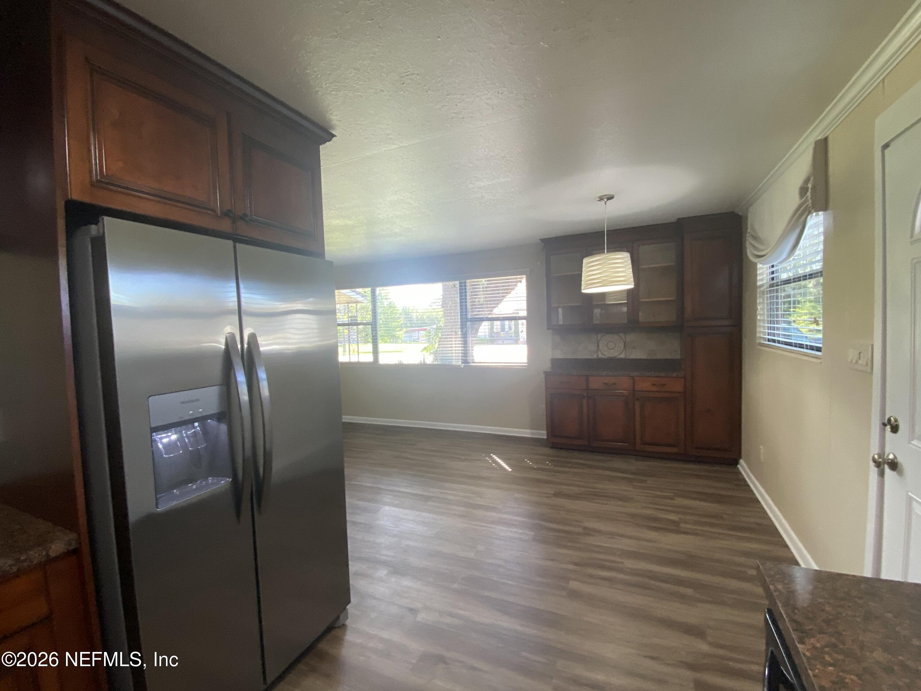 104 St Elmo Road Green Cove Springs, FL 32043 - Photo 7 of 24 a view of a kitchen with wooden floor electronic appliances and windows