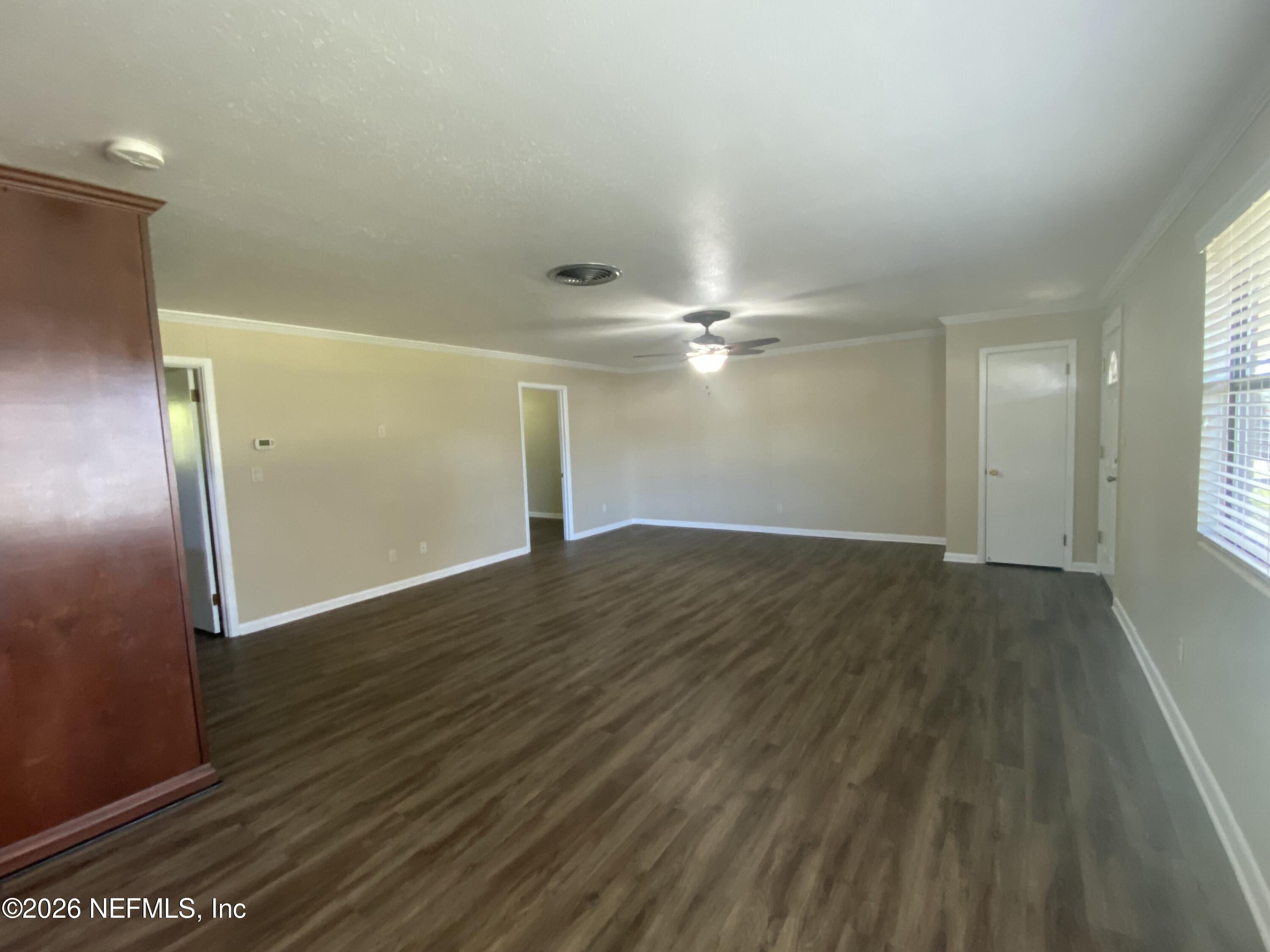 104 St Elmo Road Green Cove Springs, FL 32043 - Photo 9 of 24 an empty room with wooden floor and windows
