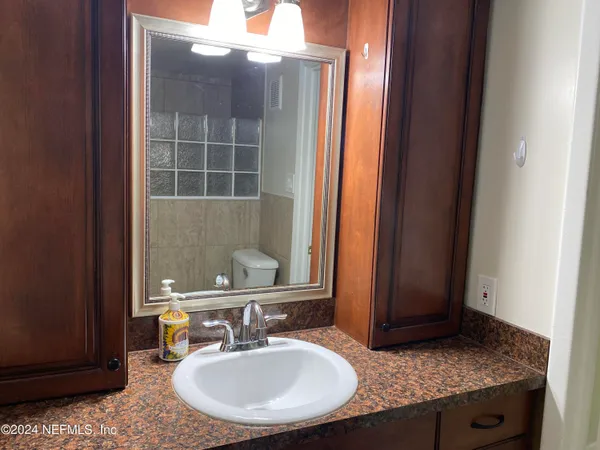 a bathroom with a granite countertop sink and a mirror