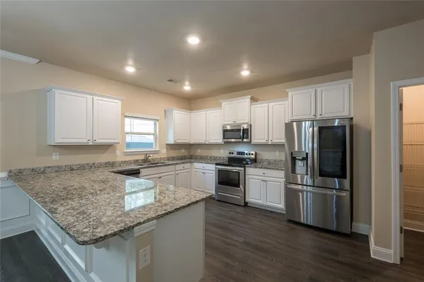 a kitchen with granite countertop stainless steel appliances and wooden cabinets