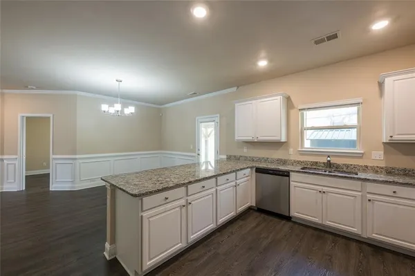 a kitchen with granite countertop sink stove and cabinets