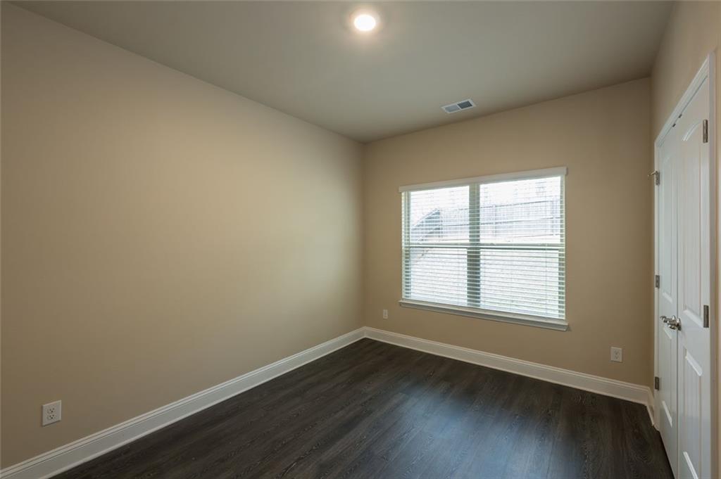 12172 Flannery Lane Hampton, GA 30228 - Photo 14 of 31 an empty room with wooden floor and windows