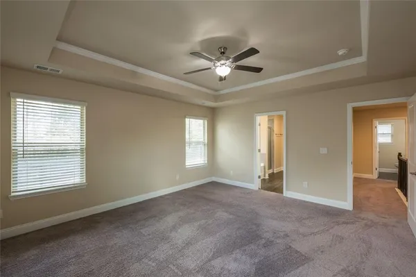 a view of a big room with windows and chandelier fan