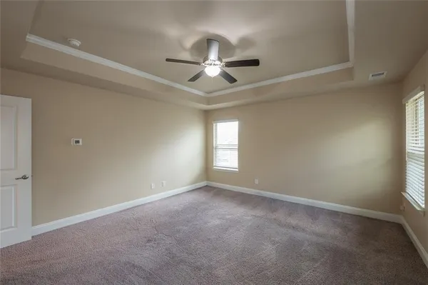 en empty room with windows and ceiling fan