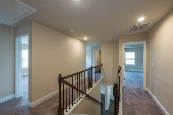 a view of a hallway with wooden floor and staircase