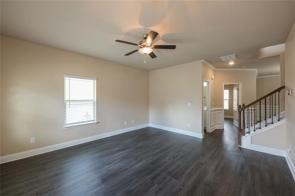 12172 Flannery Lane Hampton, GA 30228 - Photo 4 of 31 a view of an empty room with wooden floor and a ceiling fan