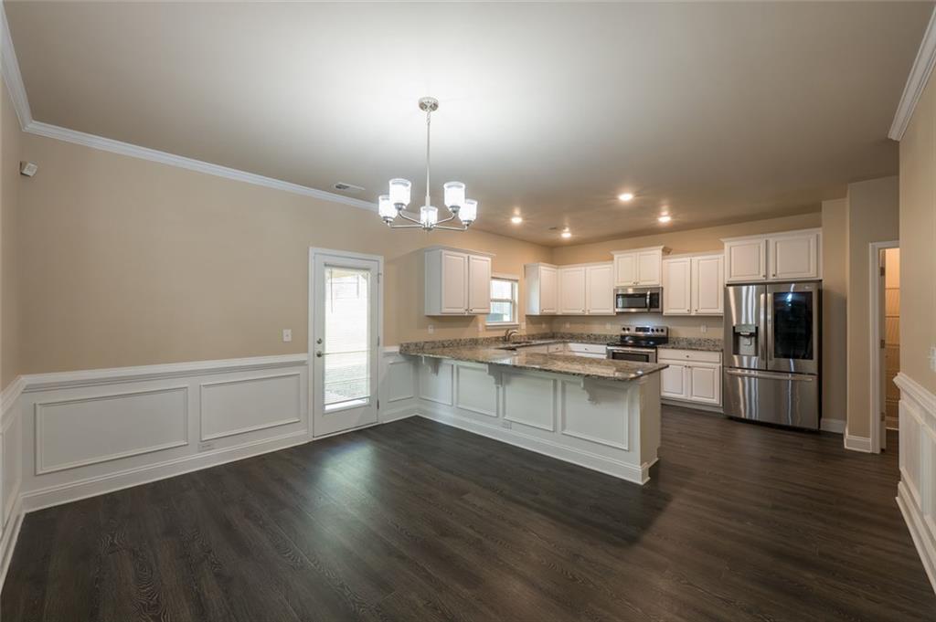 12172 Flannery Lane Hampton, GA 30228 - Photo 7 of 31 a kitchen with stainless steel appliances a refrigerator and a stove top oven