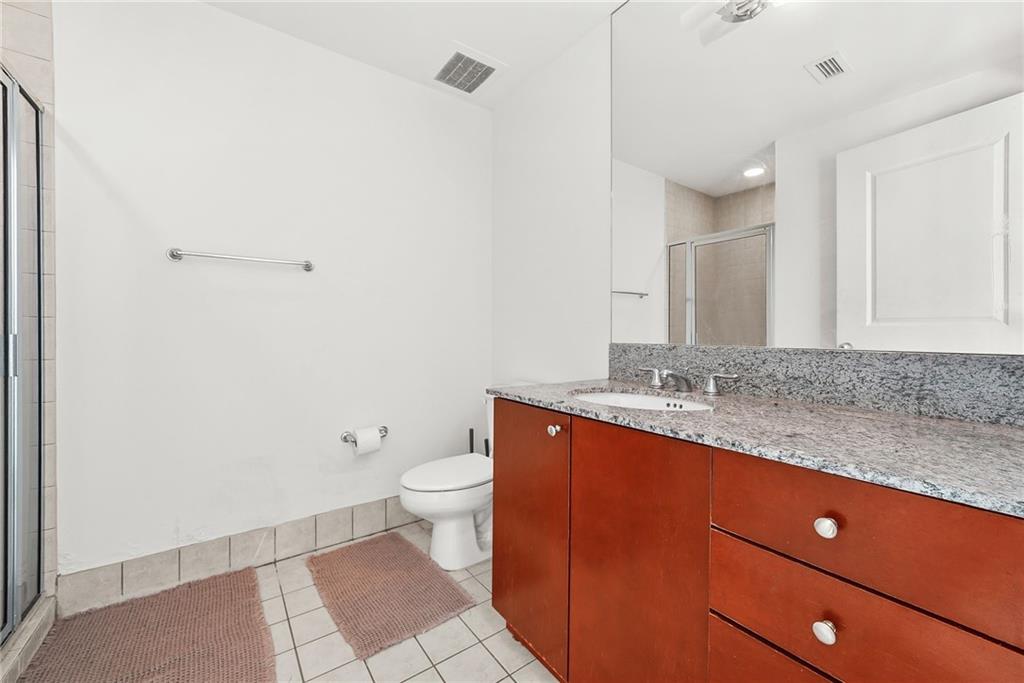 3338 Peachtree Road Northeast, Unit 3302 Atlanta, GA 30326 - Photo 15 of 42 a bathroom with a granite countertop sink mirror vanity and toilet
