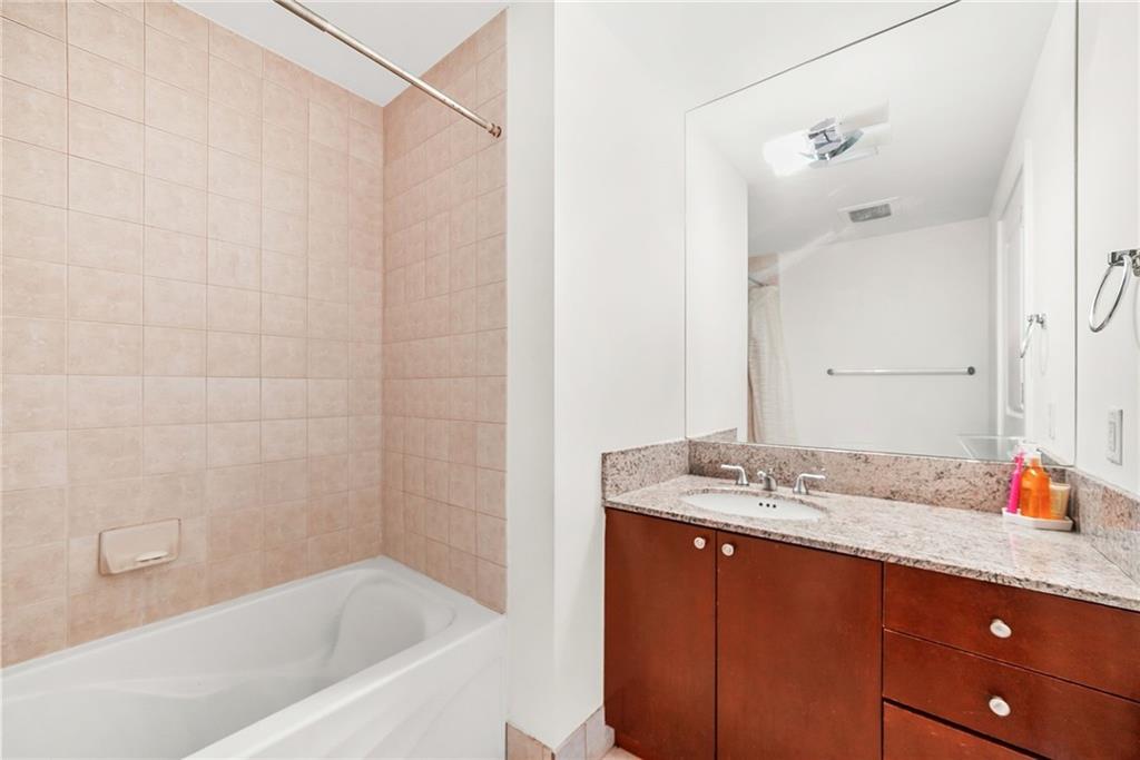 3338 Peachtree Road Northeast, Unit 3302 Atlanta, GA 30326 - Photo 17 of 42 a bathroom with a tub sink and mirror