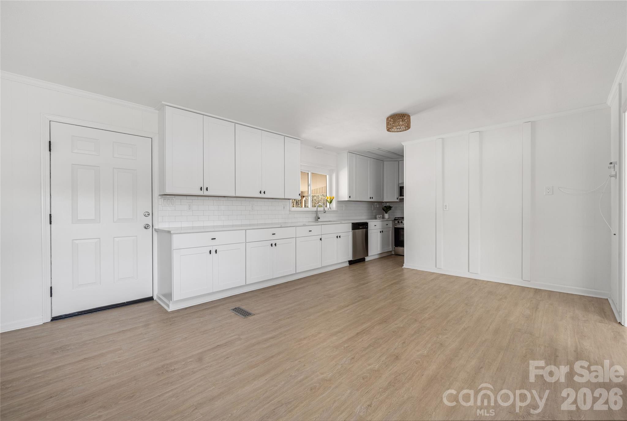 9424 Pembroke Road Huntersville, NC 28078 - Photo 11 of 39 a view of a kitchen with white cabinets and wooden floor