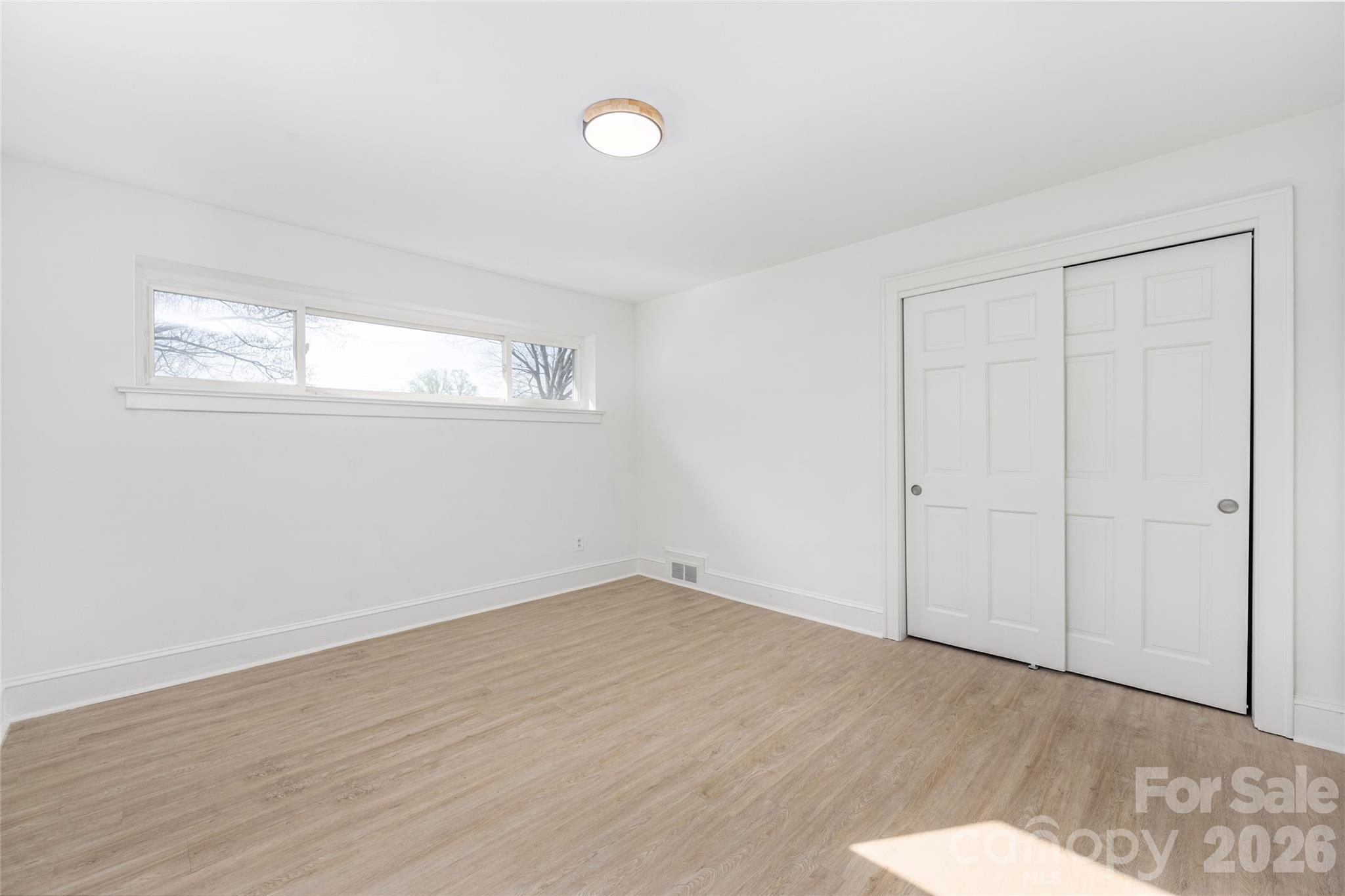 9424 Pembroke Road Huntersville, NC 28078 - Photo 19 of 39 an empty room with wooden floor and windows