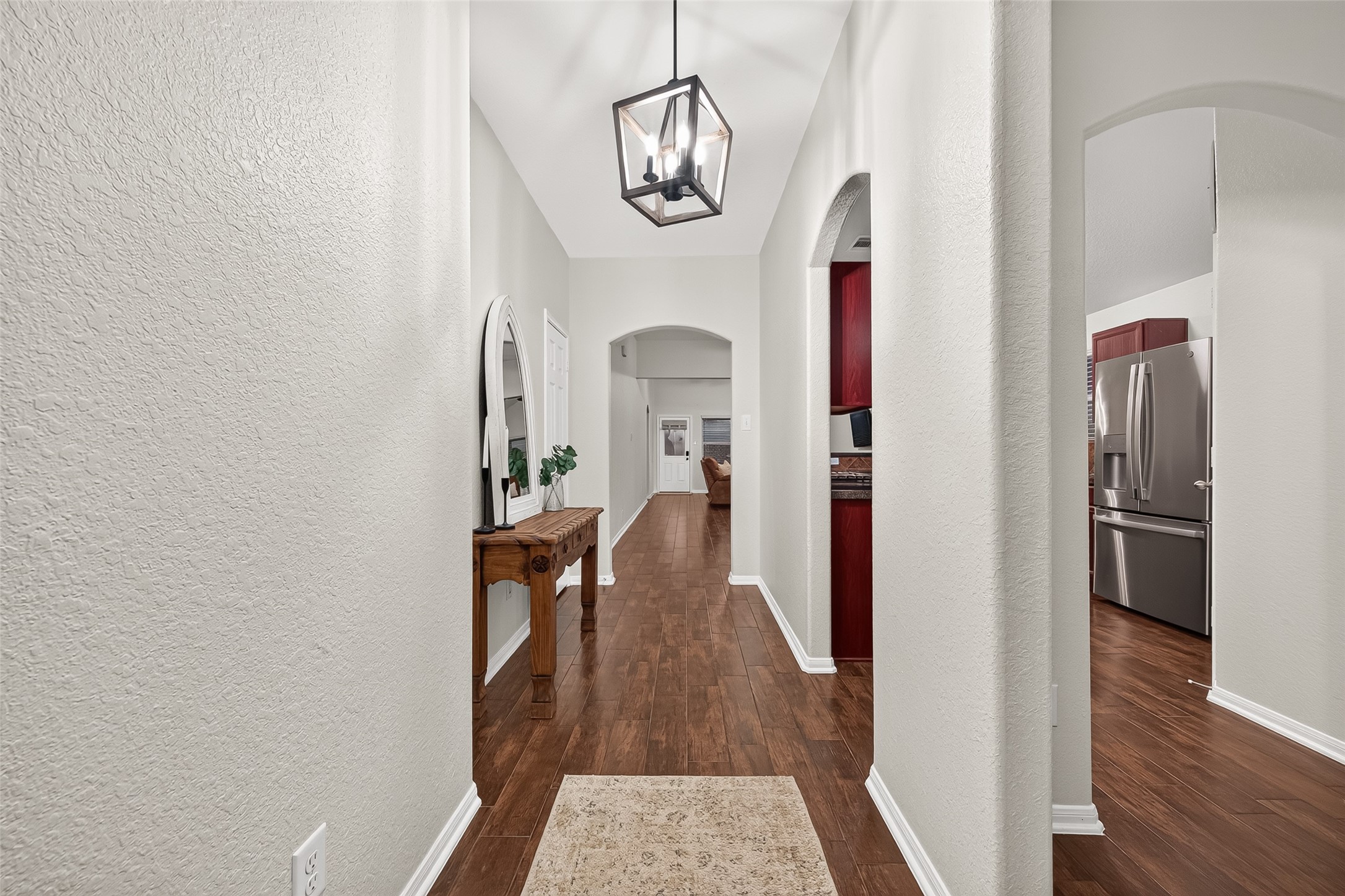 3155 View Valley Trail Katy, TX 77493 - Photo 5 of 50 Main hallway featuring beautiful wood flooring and flawless lighting, seamlessly connecting the home's living areas