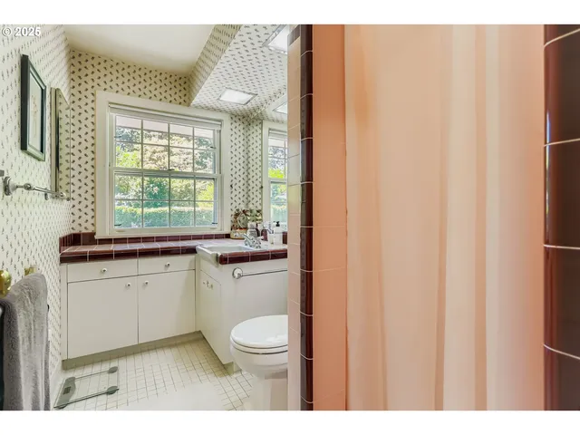 a bathroom with a sink a toilet and a window