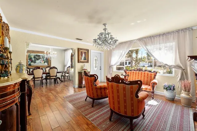 a bedroom with a bed chandelier and a window