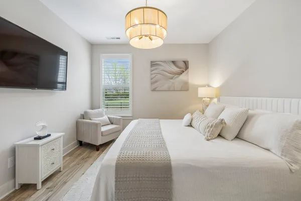 a view of a house that has a small yard and large trees
