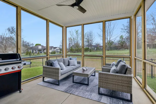a view of a white house with a big yard and large trees