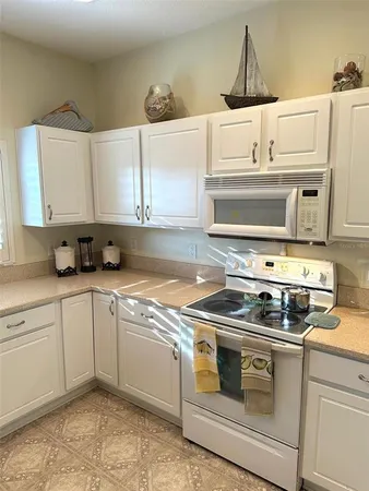a kitchen with a stove and white cabinets