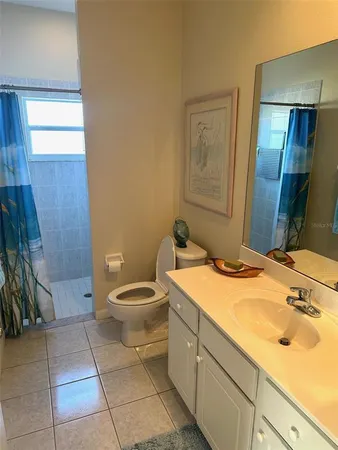 a bathroom with a granite countertop sink toilet and a mirror
