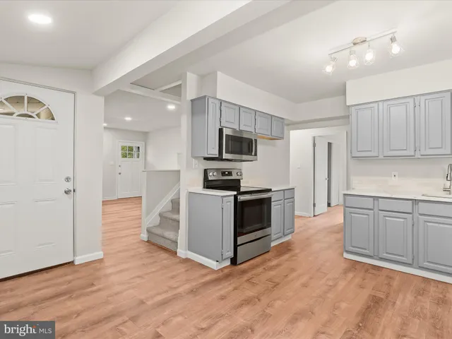 a view of kitchen with sink and refrigerator