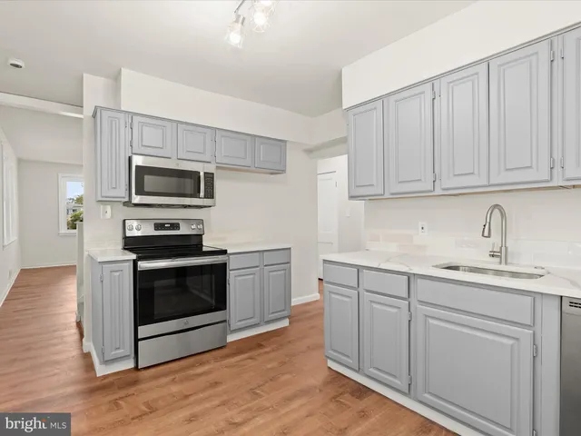 a kitchen with sink a microwave and cabinets
