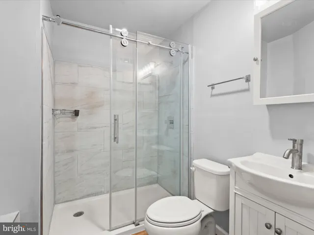 a bathroom with a shower a toilet and sink
