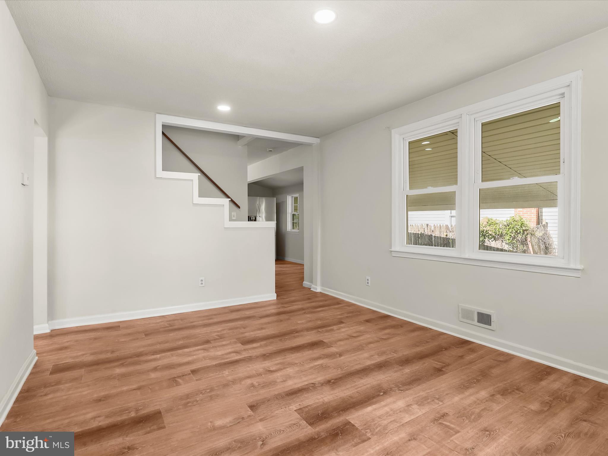 2608 Ambler Road Dundalk, MD 21222 - Photo 9 of 34 a view of an empty room with wooden floor and a window