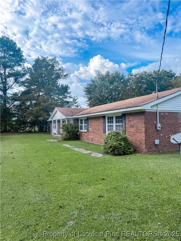 2879 County Line Road St. Pauls, NC 28384 - Photo 2 of 24 a view of a yard in front of a house with plants and large tree