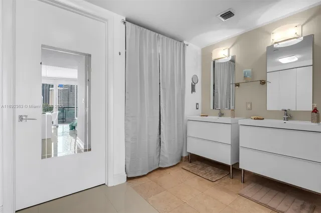 a bathroom with a sink shower and a mirror
