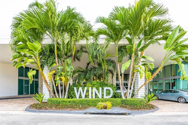 a view of a street with a building and palm trees
