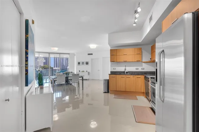 a kitchen with stainless steel appliances kitchen island granite countertop a refrigerator and a stove