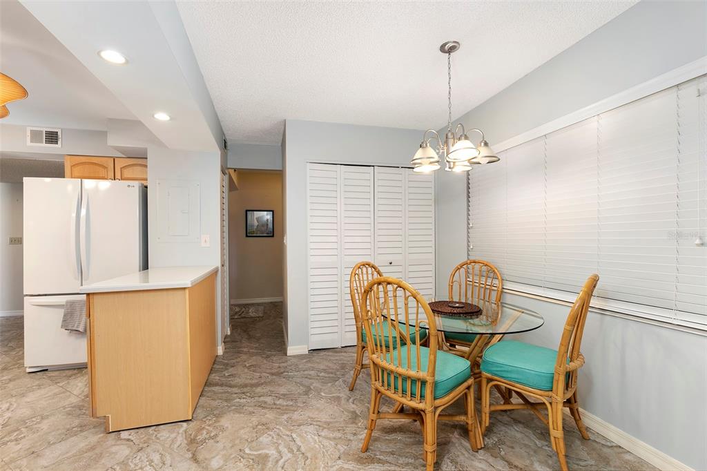6500 Sunset Way, Unit 116 St. Pete Beach, FL 33706 - Photo 12 of 56 a view of a dining room with furniture and a chandelier