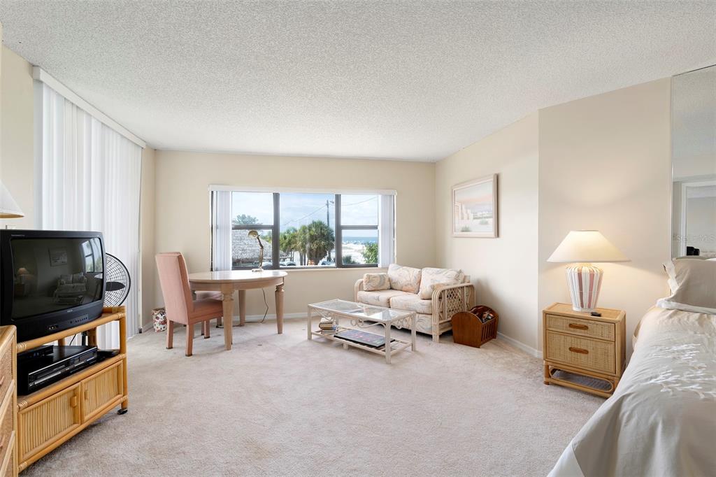 6500 Sunset Way, Unit 116 St. Pete Beach, FL 33706 - Photo 15 of 56 a living room with furniture a flat screen tv and a window