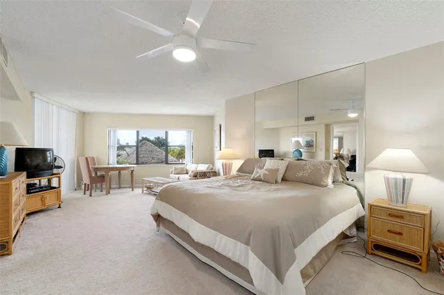 a bedroom with a large bed and a chandelier