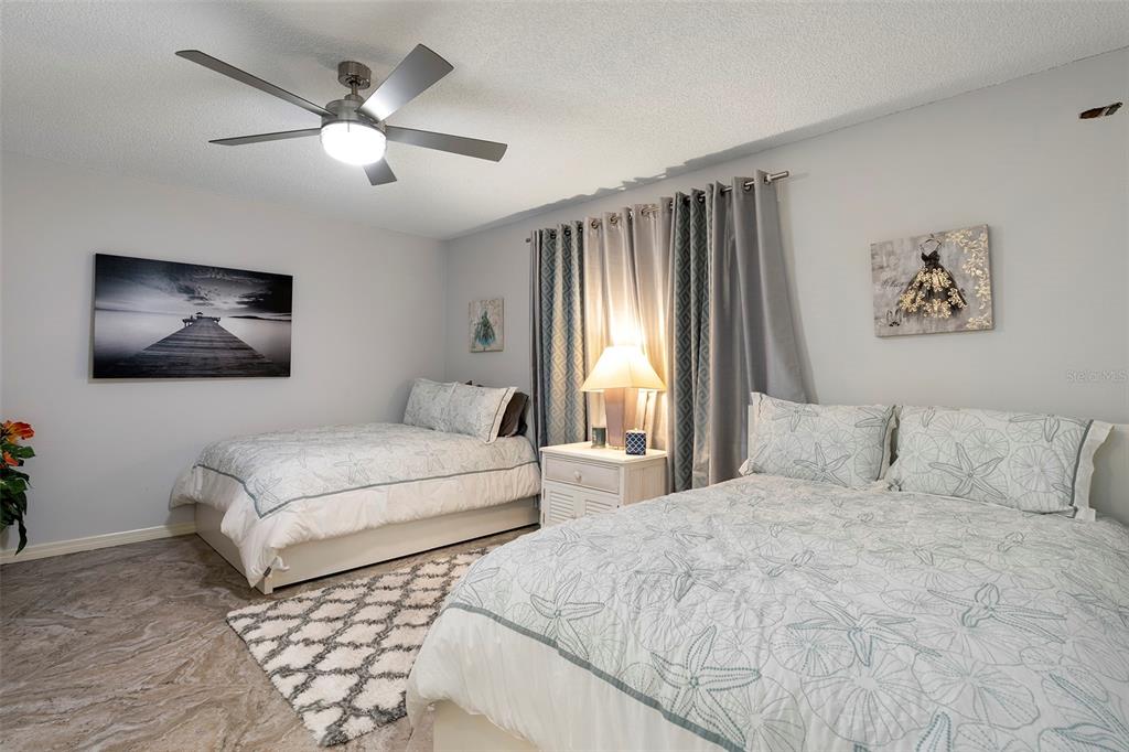 6500 Sunset Way, Unit 116 St. Pete Beach, FL 33706 - Photo 20 of 56 a bedroom with a large bed and a chandelier