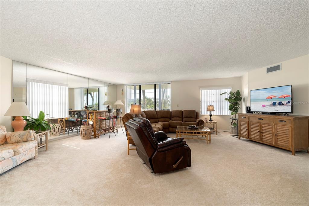 6500 Sunset Way, Unit 116 St. Pete Beach, FL 33706 - Photo 27 of 56 a living room with furniture and a flat screen tv