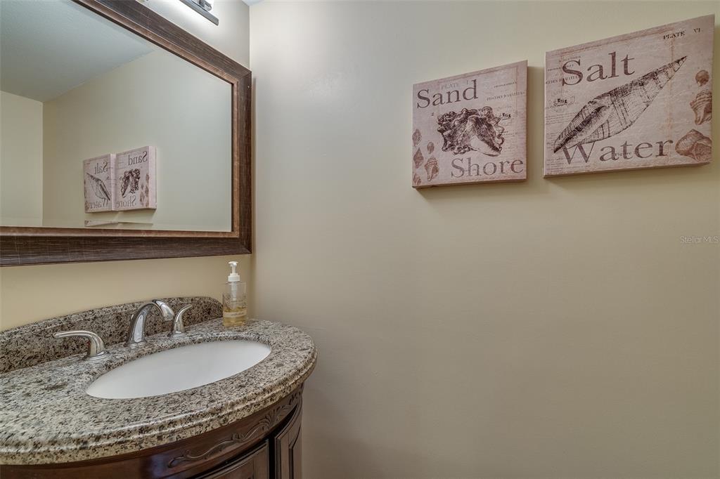 6500 Sunset Way, Unit 116 St. Pete Beach, FL 33706 - Photo 29 of 56 a bathroom with a granite countertop sink and a mirror
