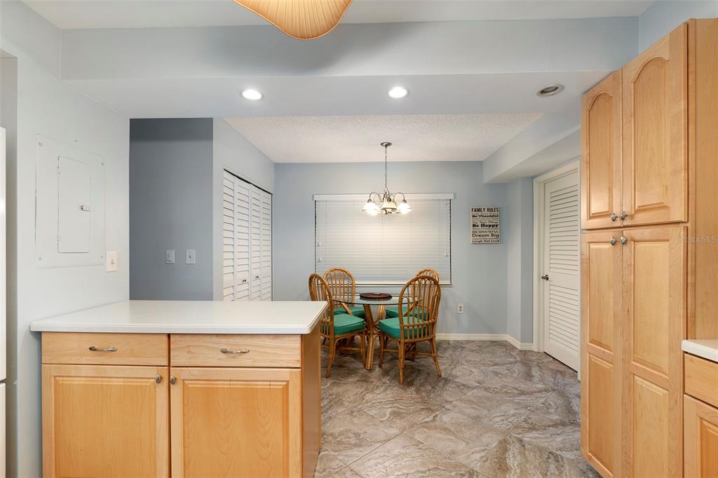 6500 Sunset Way, Unit 116 St. Pete Beach, FL 33706 - Photo 30 of 56 a view of a kitchen with dining area and chandelier