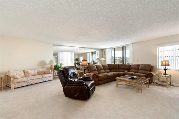 a living room with furniture a flat screen tv and a window