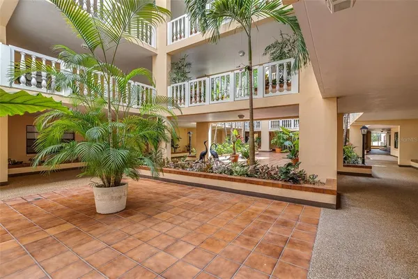 a front view of a residential apartment building with a yard and potted plants
