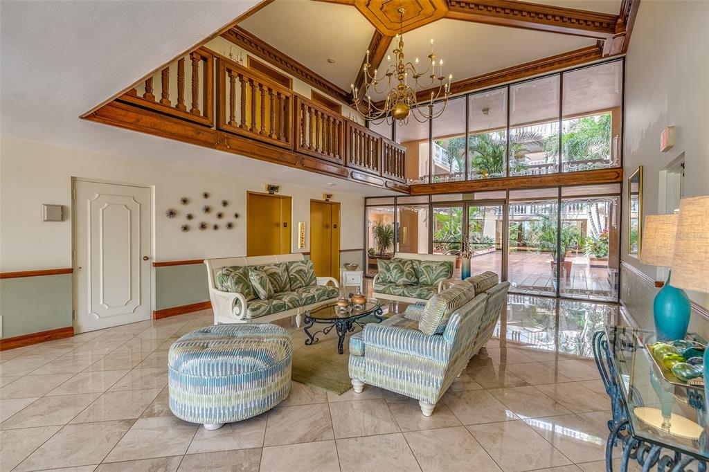6500 Sunset Way, Unit 116 St. Pete Beach, FL 33706 - Photo 38 of 56 a living room with furniture and a chandelier