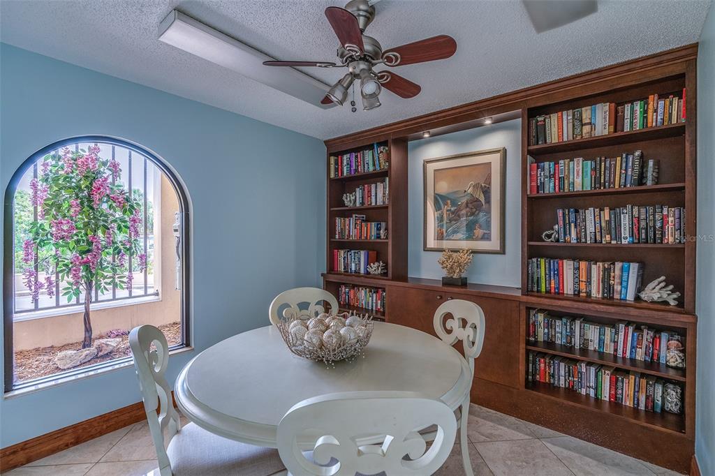 6500 Sunset Way, Unit 116 St. Pete Beach, FL 33706 - Photo 39 of 56 a dining room with furniture a book shelf