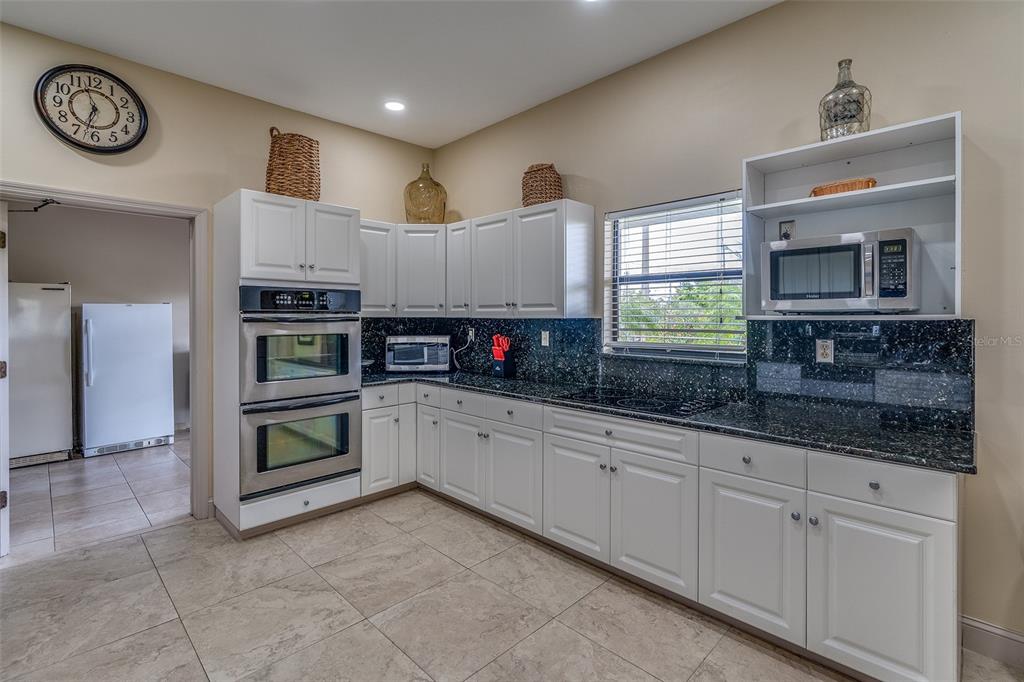 6500 Sunset Way, Unit 116 St. Pete Beach, FL 33706 - Photo 46 of 56 a kitchen with stainless steel appliances granite countertop a sink and cabinets