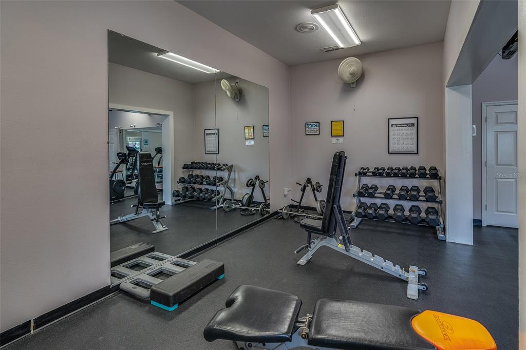 6500 Sunset Way, Unit 116 St. Pete Beach, FL 33706 - Photo 49 of 56 a room with gym equipment and a mirror