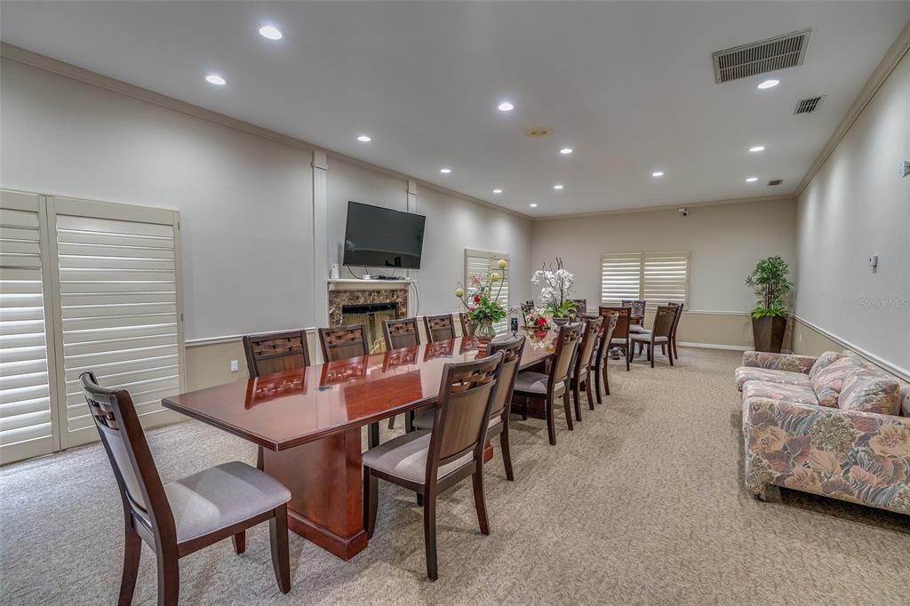 6500 Sunset Way, Unit 116 St. Pete Beach, FL 33706 - Photo 51 of 56 a dining room with furniture and a flat screen tv