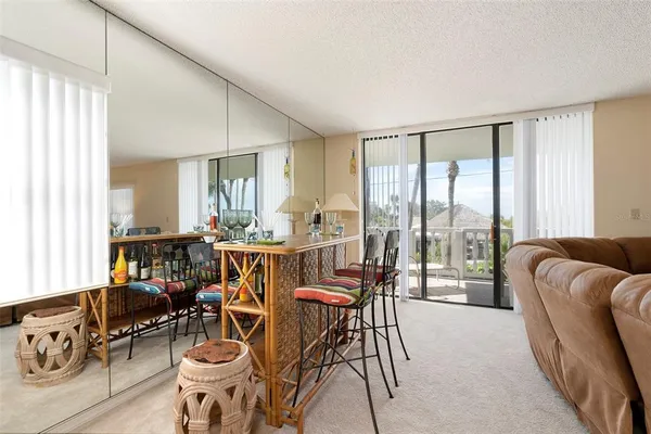 a dining room with furniture potted plants and wooden floor