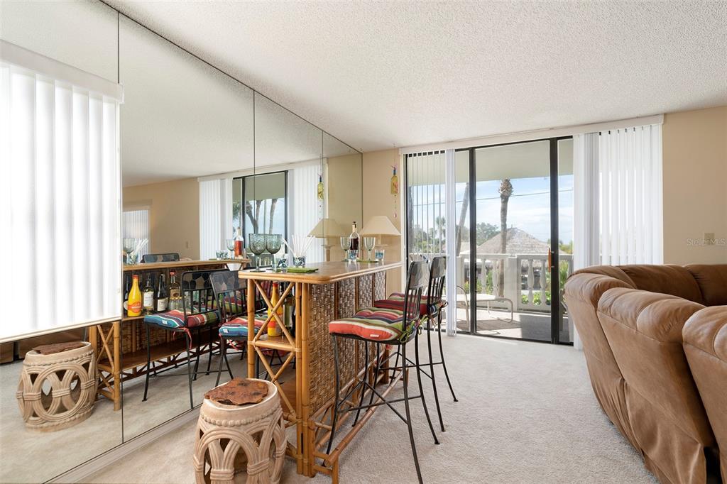 6500 Sunset Way, Unit 116 St. Pete Beach, FL 33706 - Photo 7 of 56 a dining room with furniture and large windows